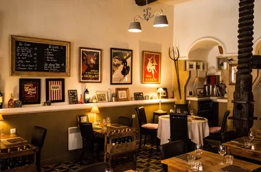 Salle de L’Auberge Provençale au Lavandou, avec poutres et tables dressées