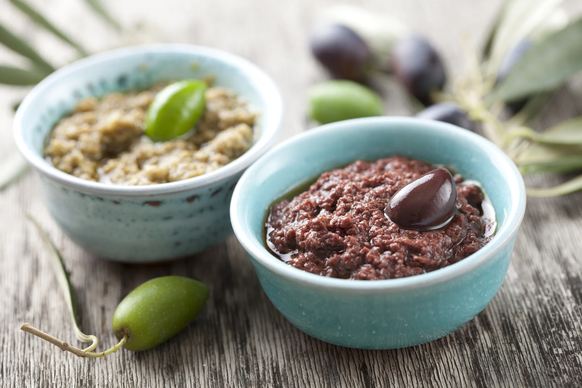Deux bols de tapenade, l’un aux olives vertes et l’autre aux olives noires