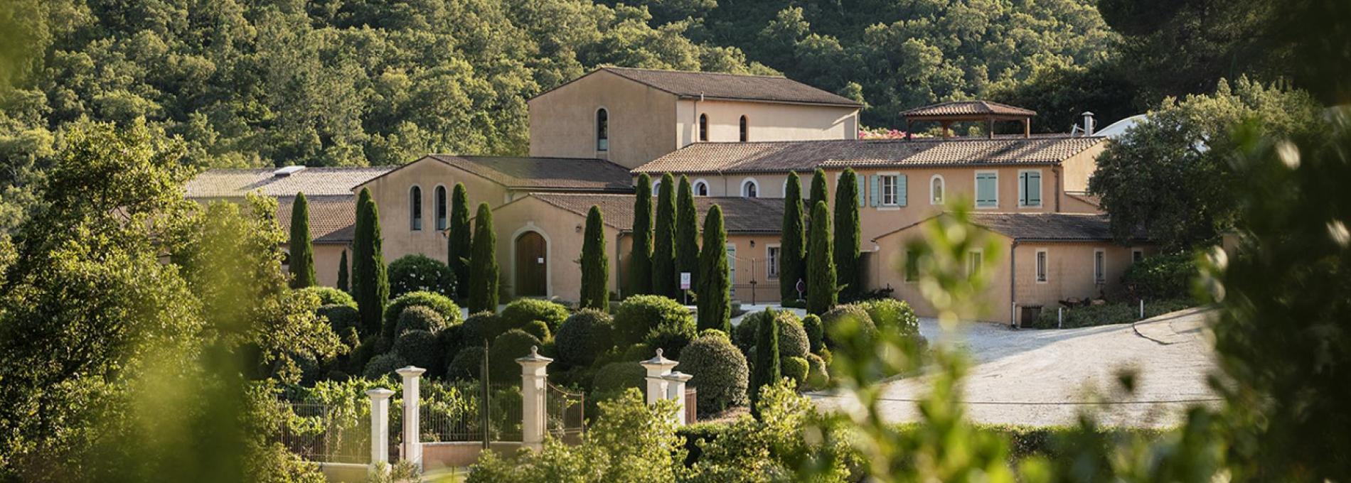 Château Pas du Cerf entouré de cyprès et de collines boisées
